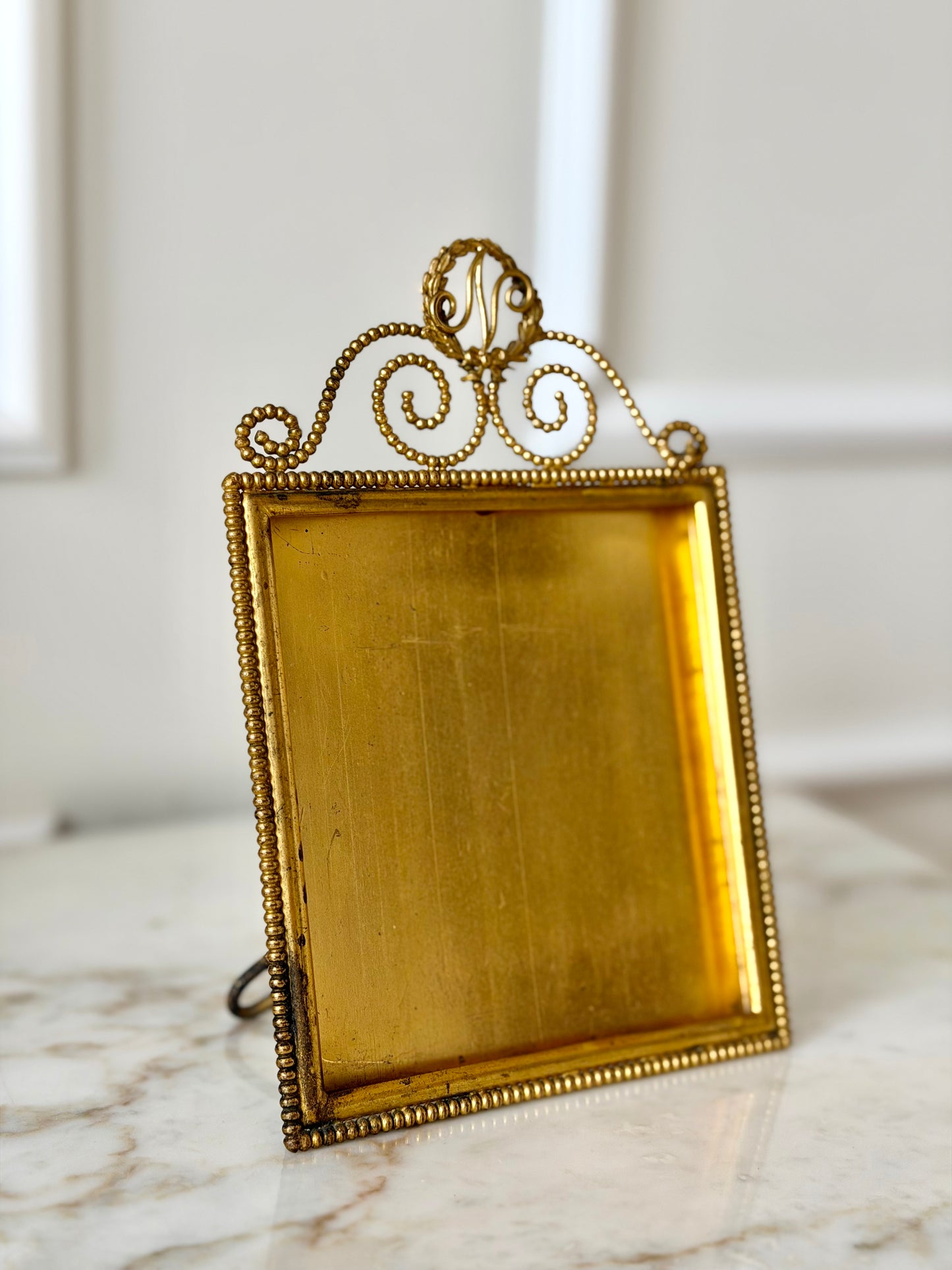 Gilt initial “N” frame