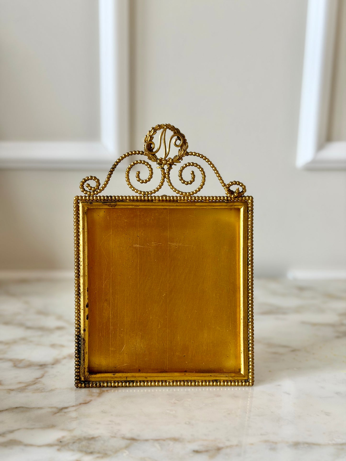 Gilt initial “N” frame