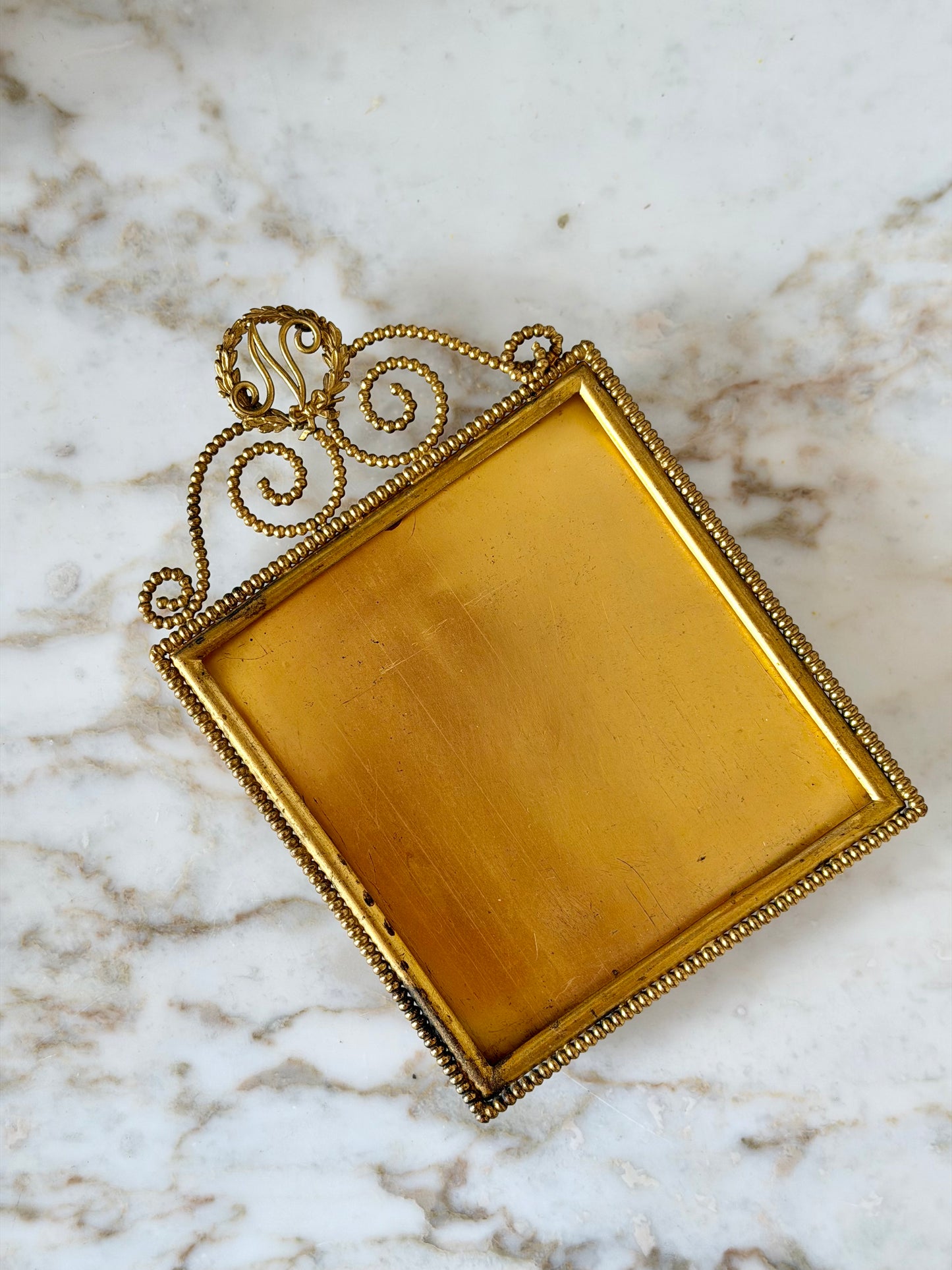 Gilt initial “N” frame